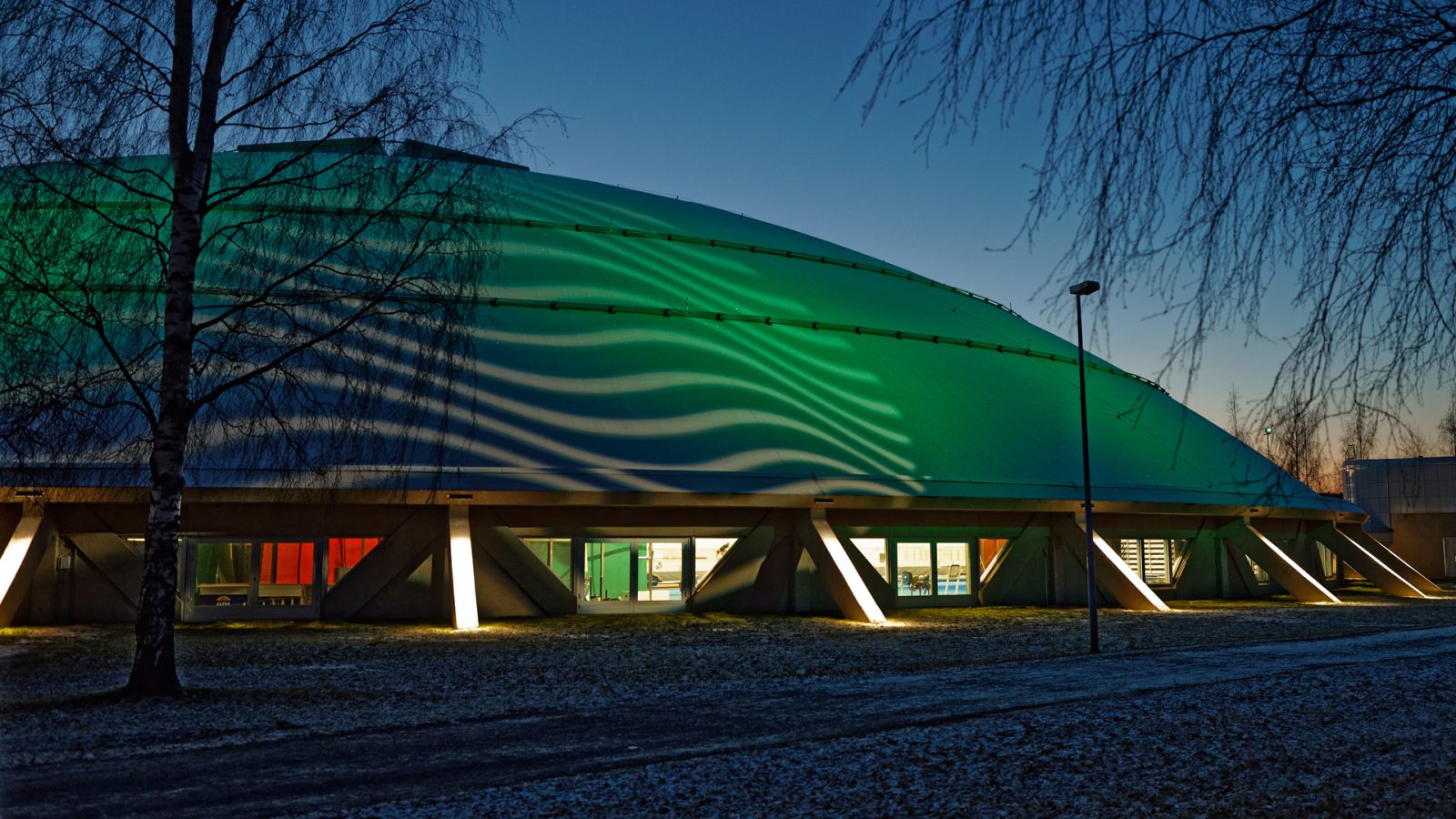 The dome of Oulu hall is lit green.